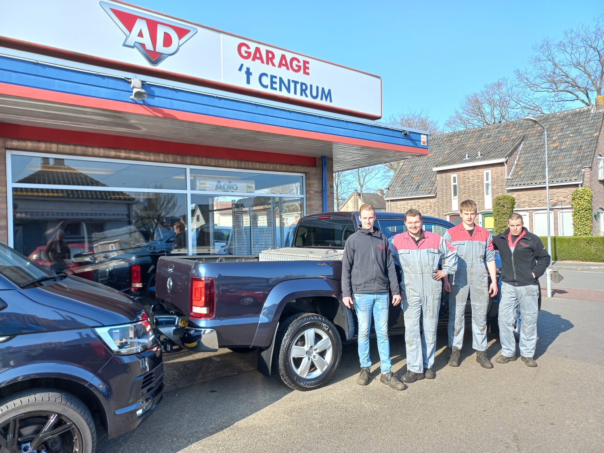 De monteurs van Garage 't Centrum voor de gevel aan de Eperweg, met een Volkswagen Amarok op het plein
